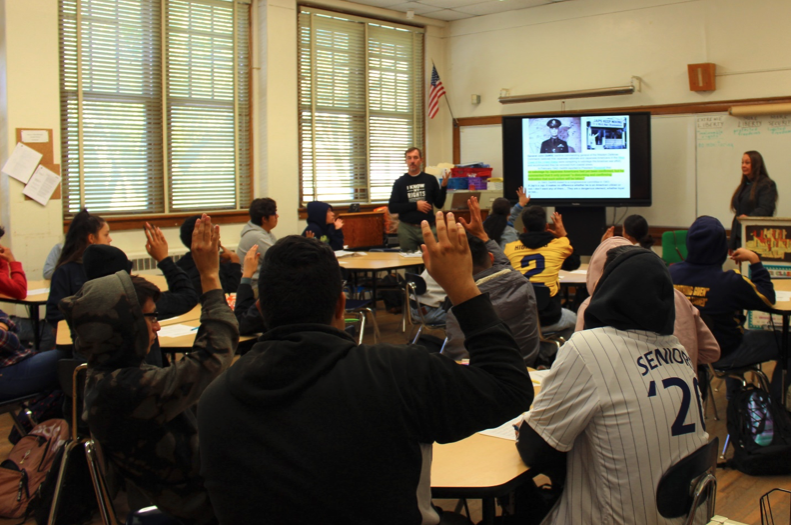 Students raise their hands in agreement that they could imagine immigrants in the United States becoming the targets of government sanctioned racial profiling in the name of national security. Photo by Sal Guardiola II