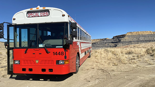 Bus tour bus parked in front of a mesa in the pueblo of laguna
