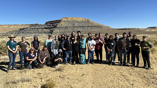 a group of students posing outside in front of a mesa