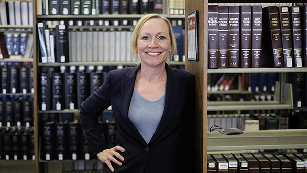 Photo of Camille Carey in UNM Law Library in front of a bookshelf
