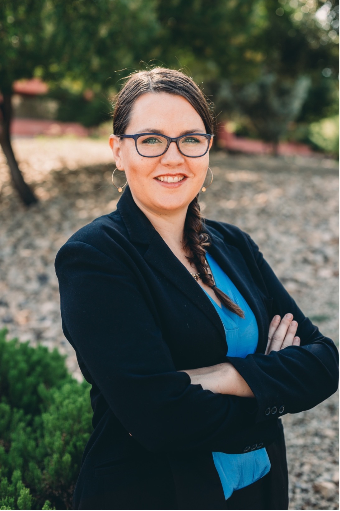 Jessica Miles, adult woman with glasses and long brown hair, dressed in a sport coat