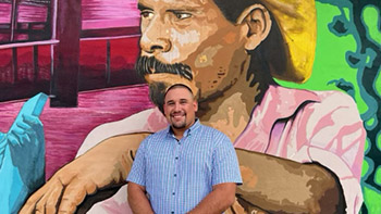 jorge rodriguez, adult hispanic man standing in front of a mural